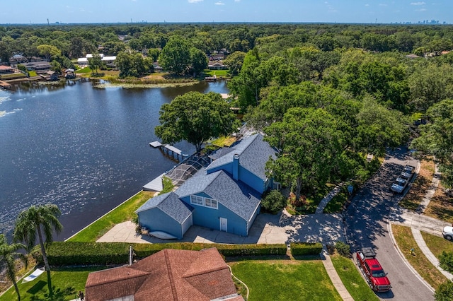 birds eye view of property featuring a water view and a wooded view