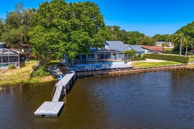 view of dock featuring fence, glass enclosure, and a water view