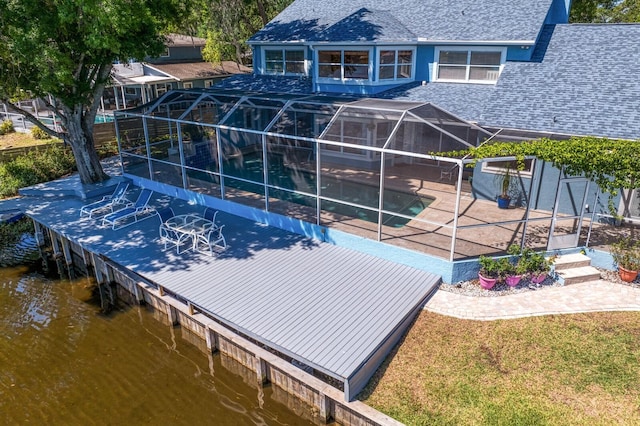 exterior space featuring metal roof, a patio area, a fenced in pool, a water view, and a shingled roof