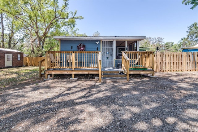 5304 Cherry Ave, Seffner, FL 33584 - back of house with fence, a wooden deck, an outdoor structure, and a sunroom