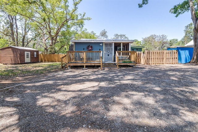 5304 Cherry Ave, Seffner, FL 33584 - back of house featuring fence, a wooden deck, an outdoor structure, and a shed