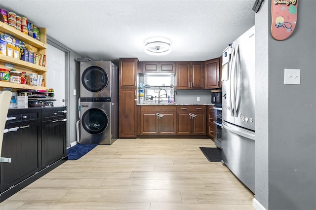 5304 Cherry Ave, Seffner, FL 33584 - washroom featuring laundry area, a sink, a textured ceiling, light wood-style flooring, and stacked washer and clothes dryer