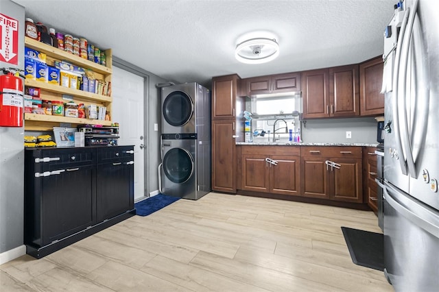 5304 Cherry Ave, Seffner, FL 33584 - clothes washing area featuring a textured ceiling, stacked washer / drying machine, baseboards, and laundry area