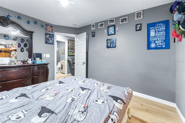 5304 Cherry Ave, Seffner, FL 33584 - bedroom featuring baseboards, wood finished floors, and connected bathroom