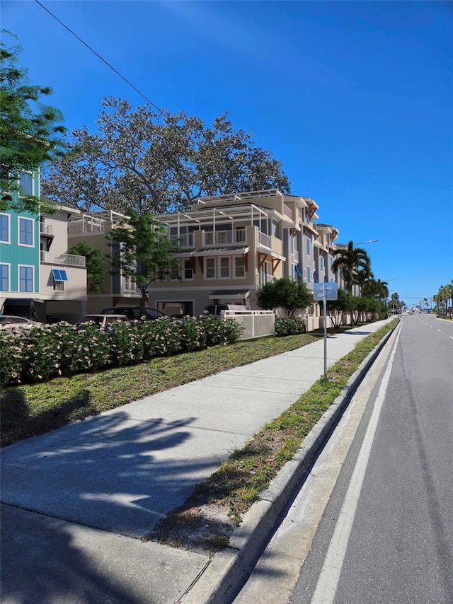 view of asphalt street featuring sidewalks and curbs
