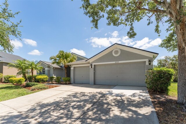 ranch-style home featuring concrete driveway, a garage, and stucco siding