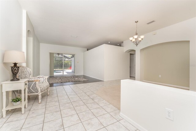 interior space with visible vents, an inviting chandelier, baseboards, arched walkways, and light tile patterned floors