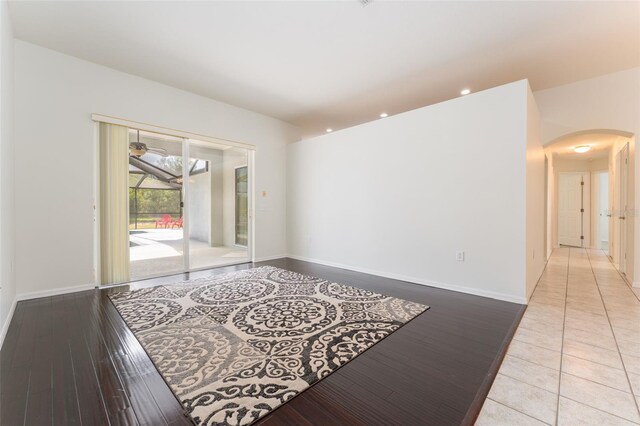 empty room featuring arched walkways, baseboards, recessed lighting, and ceiling fan