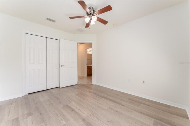 unfurnished bedroom featuring a closet, baseboards, visible vents, and light wood-type flooring