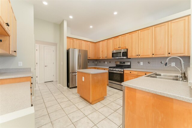 kitchen featuring a sink, appliances with stainless steel finishes, light tile patterned floors, and light brown cabinetry