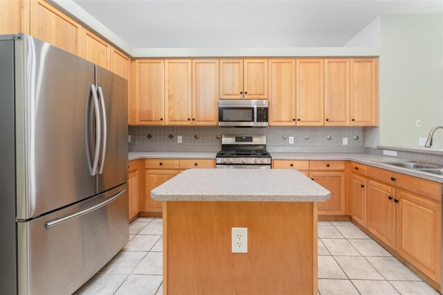 kitchen with light brown cabinetry, a sink, light countertops, stainless steel appliances, and light tile patterned flooring