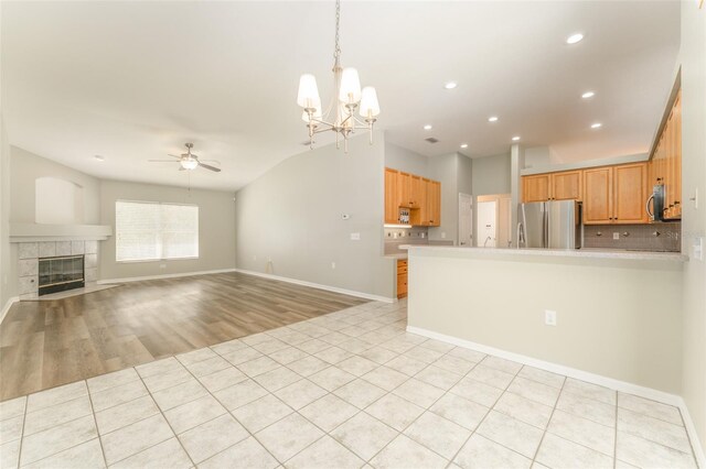 unfurnished living room with light tile patterned floors, baseboards, ceiling fan with notable chandelier, and recessed lighting