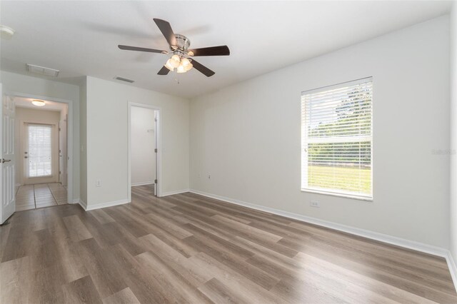 empty room featuring visible vents, plenty of natural light, and wood finished floors