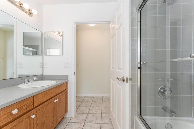 bathroom featuring tile patterned floors, combined bath / shower with glass door, and vanity