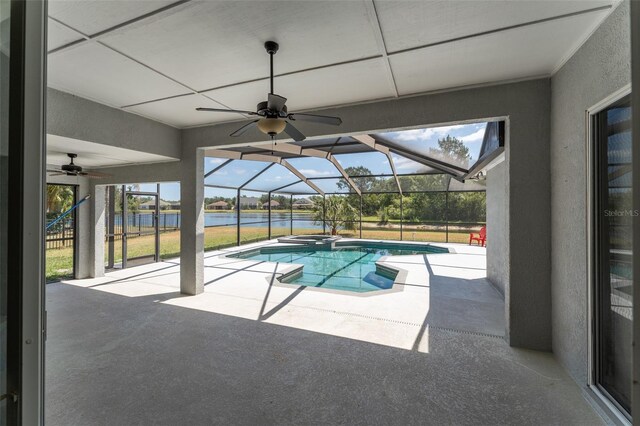 view of pool featuring ceiling fan, a patio, a water view, glass enclosure, and a pool with connected hot tub