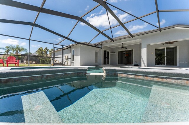 outdoor pool with a lanai, ceiling fan, and a patio area