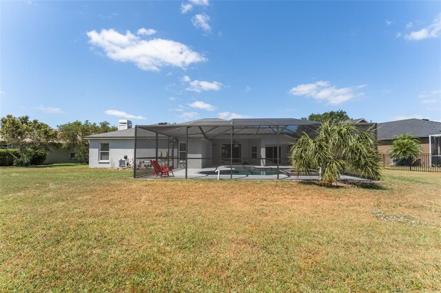 rear view of house with a fenced in pool, glass enclosure, a patio area, and a yard