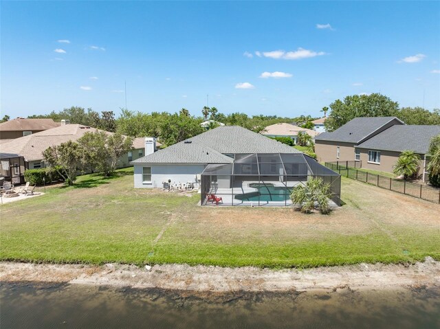 rear view of property with a lanai, a lawn, a residential view, an outdoor pool, and a patio