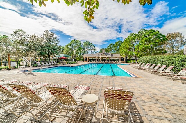 pool with fence and a patio area