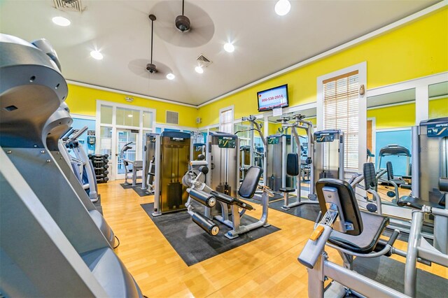 gym with crown molding, ceiling fan, visible vents, and wood finished floors