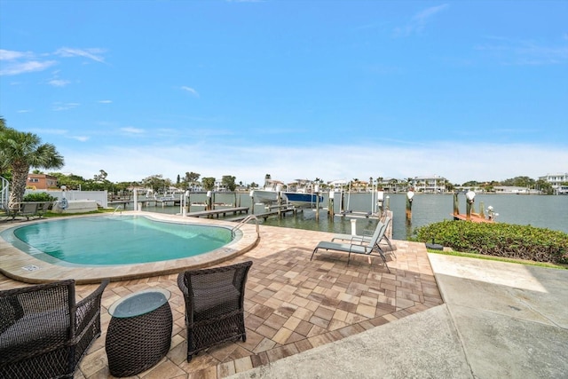 pool featuring a water view, a patio area, boat lift, and a dock