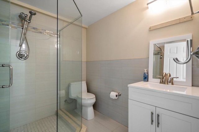 full bathroom with vanity, toilet, tile walls, tile patterned floors, and a shower stall