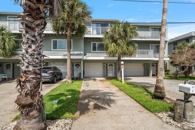 multi unit property featuring an attached garage, driveway, and stucco siding