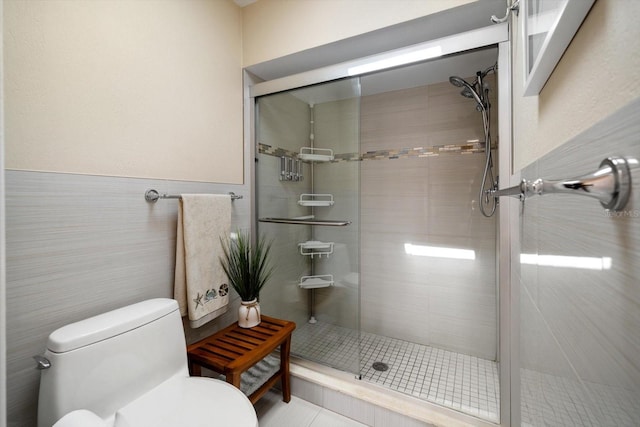 full bathroom with wainscoting, tile walls, a shower stall, and toilet