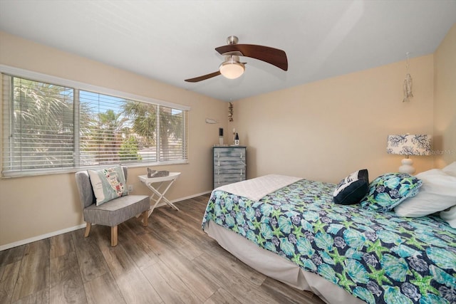 bedroom with baseboards, a ceiling fan, and wood finished floors