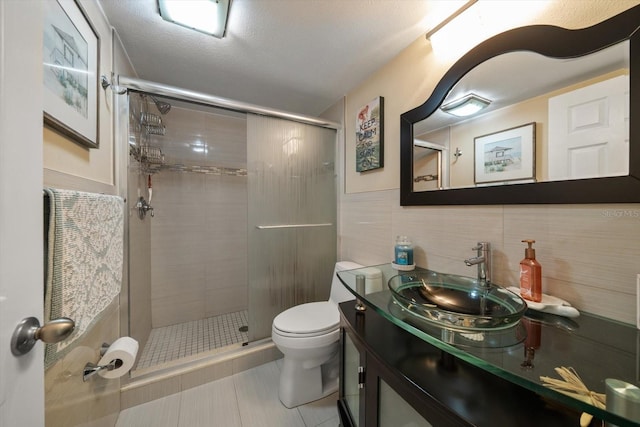 full bathroom featuring tile patterned flooring, vanity, toilet, tile walls, and a stall shower