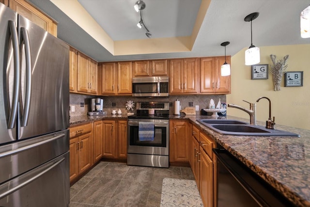 kitchen with brown cabinets, stainless steel appliances, a sink, and tasteful backsplash