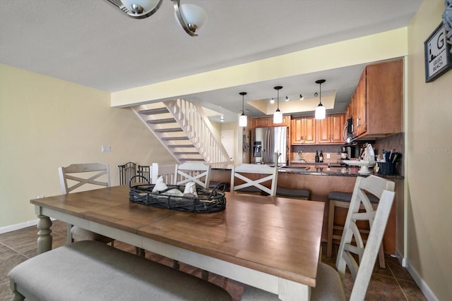 dining space with baseboards and stairway