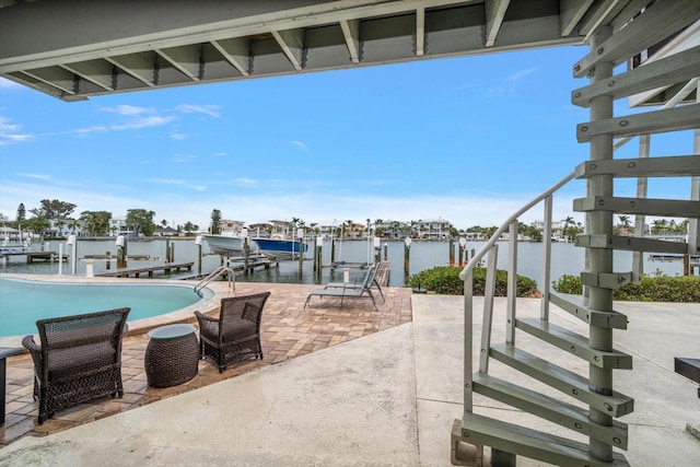 view of patio / terrace featuring boat lift, a water view, a dock, and an outdoor pool