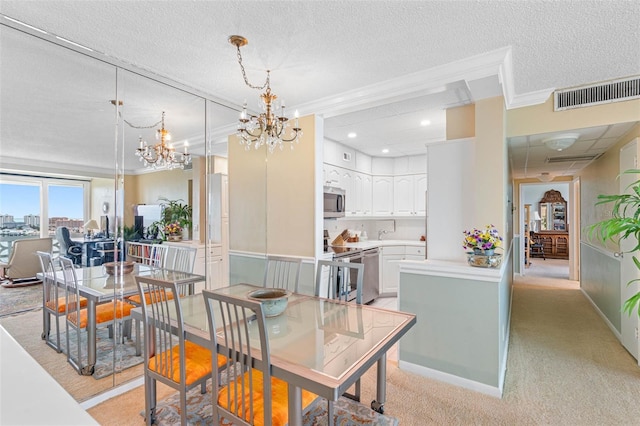 dining space featuring a textured ceiling, light colored carpet, visible vents, a chandelier, and ornamental molding