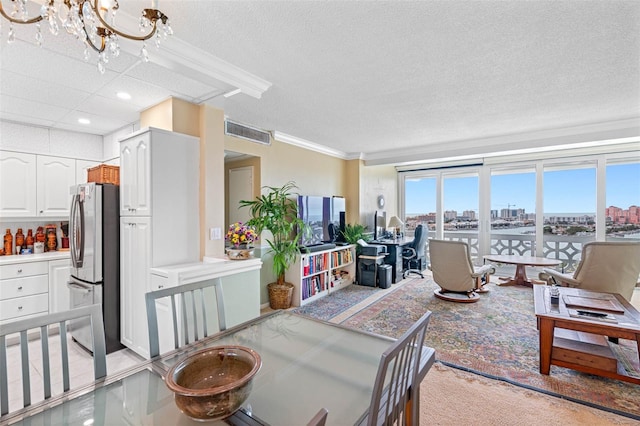 living room with light carpet, a textured ceiling, a chandelier, visible vents, and ornamental molding