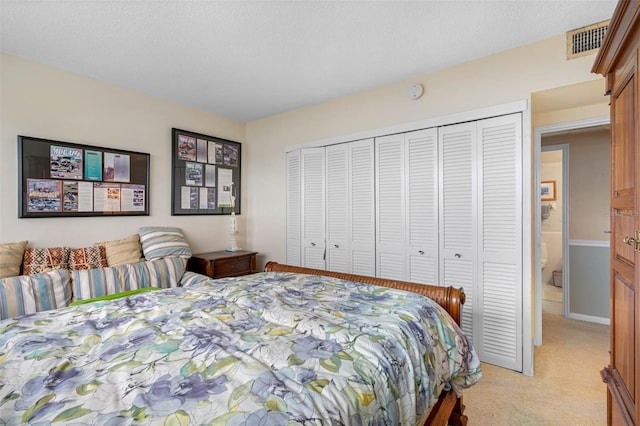 bedroom featuring light colored carpet, visible vents, and a closet