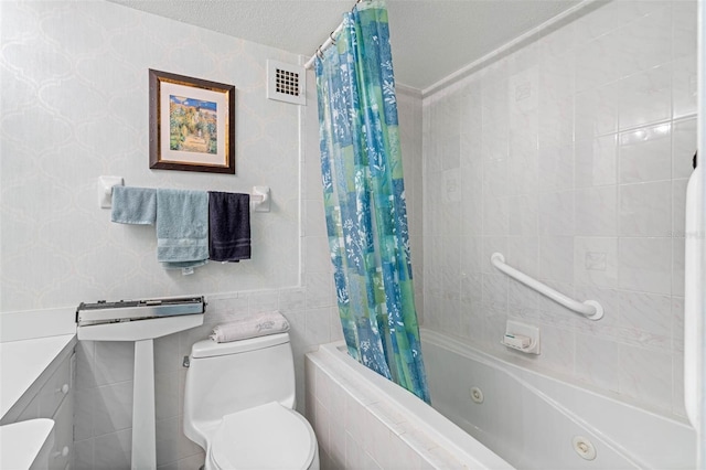 full bath with toilet, visible vents, tile walls, and a combined bath / shower with jetted tub