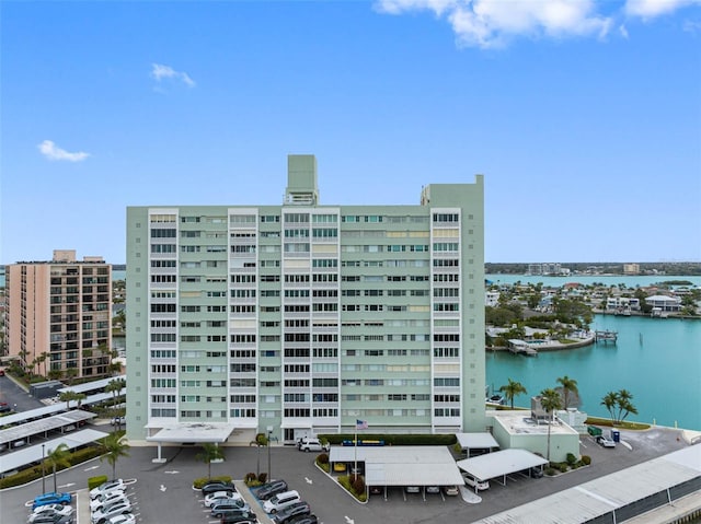 view of property featuring a water view, uncovered parking, and a city view