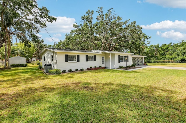 ranch-style home with driveway, cooling unit, and a front yard