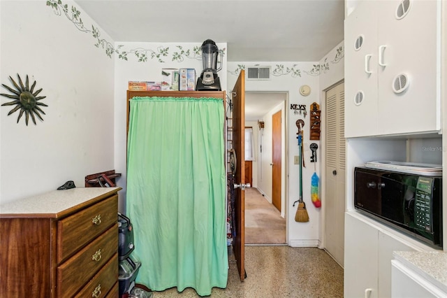 bedroom featuring a closet, visible vents, and light speckled floor