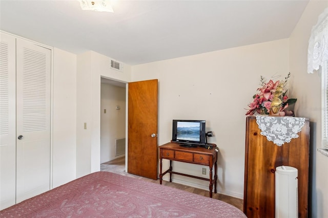 bedroom featuring baseboards and visible vents