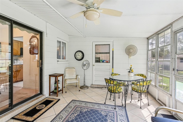 sunroom / solarium featuring outdoor dining area and ceiling fan