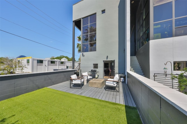 rear view of property featuring stairs, an outdoor living space, and stucco siding