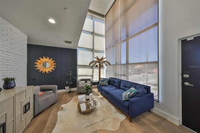 living room featuring baseboards, wood finished floors, and a healthy amount of sunlight