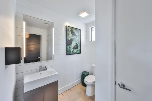 bathroom featuring vanity, wood finished floors, and toilet