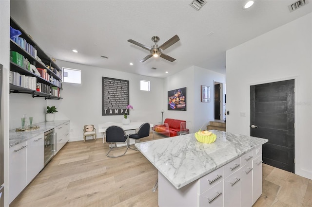 kitchen featuring white cabinets, open shelves, visible vents, and light wood-style floors
