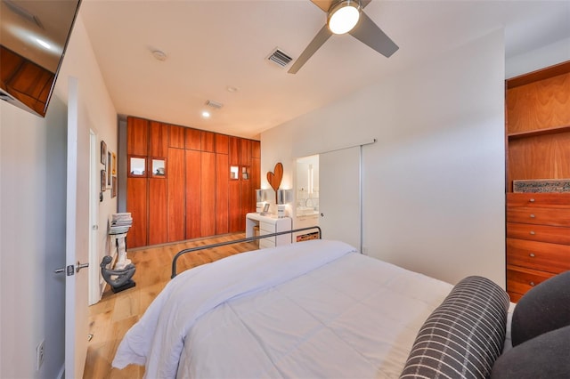 bedroom with recessed lighting, a ceiling fan, washer / dryer, wood finished floors, and visible vents