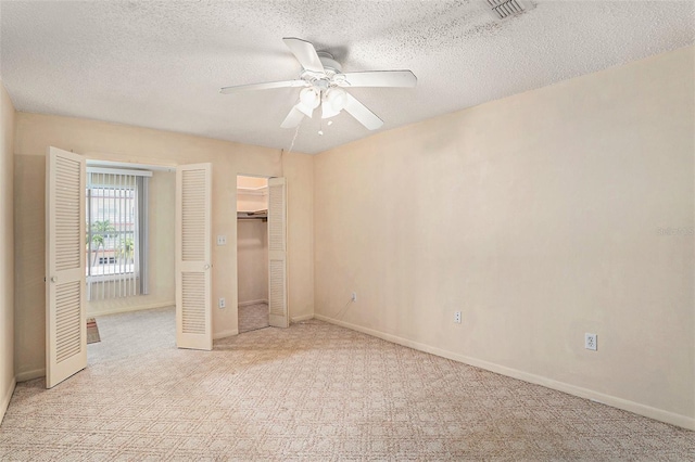 3128 59th St S Unit 206, Gulfport, FL 33707 - unfurnished bedroom with visible vents, baseboards, light colored carpet, a textured ceiling, and a ceiling fan