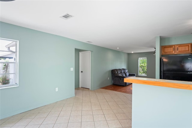3353 Montano Ave, Spring Hill, FL 34609 - kitchen with freestanding refrigerator, visible vents, ceiling fan, light tile patterned floors, and baseboards
