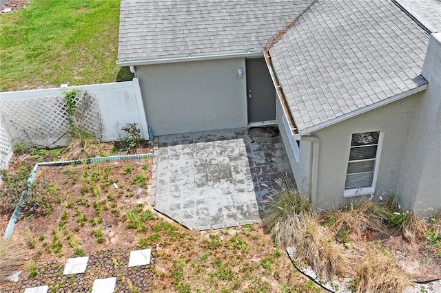 3353 Montano Ave, Spring Hill, FL 34609 - details with stucco siding, a shingled roof, and fence